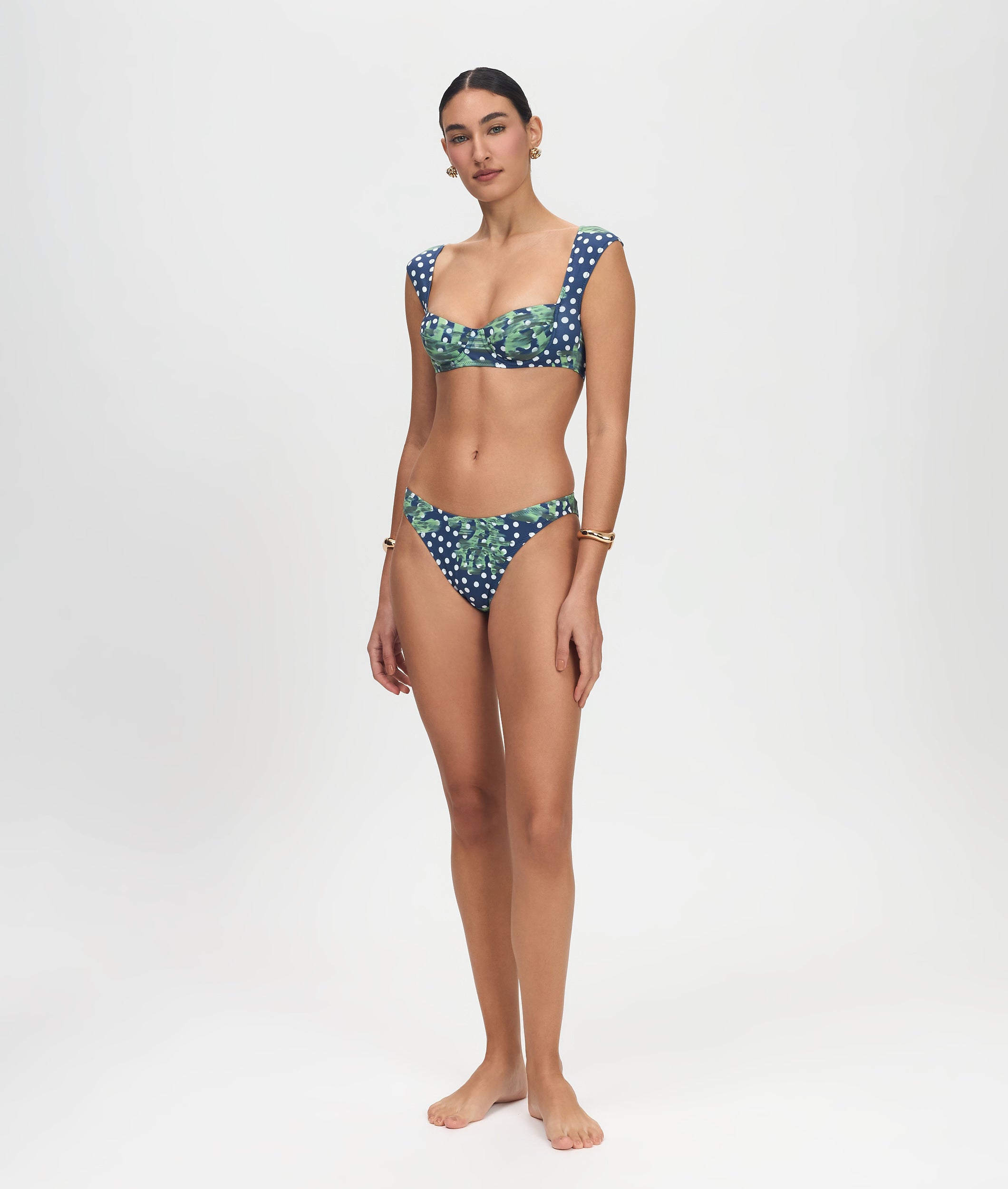 Woman wearing a blue and green patterned bikini on a white background