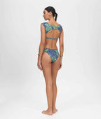 Woman wearing a blue and green patterned bikini on a white background