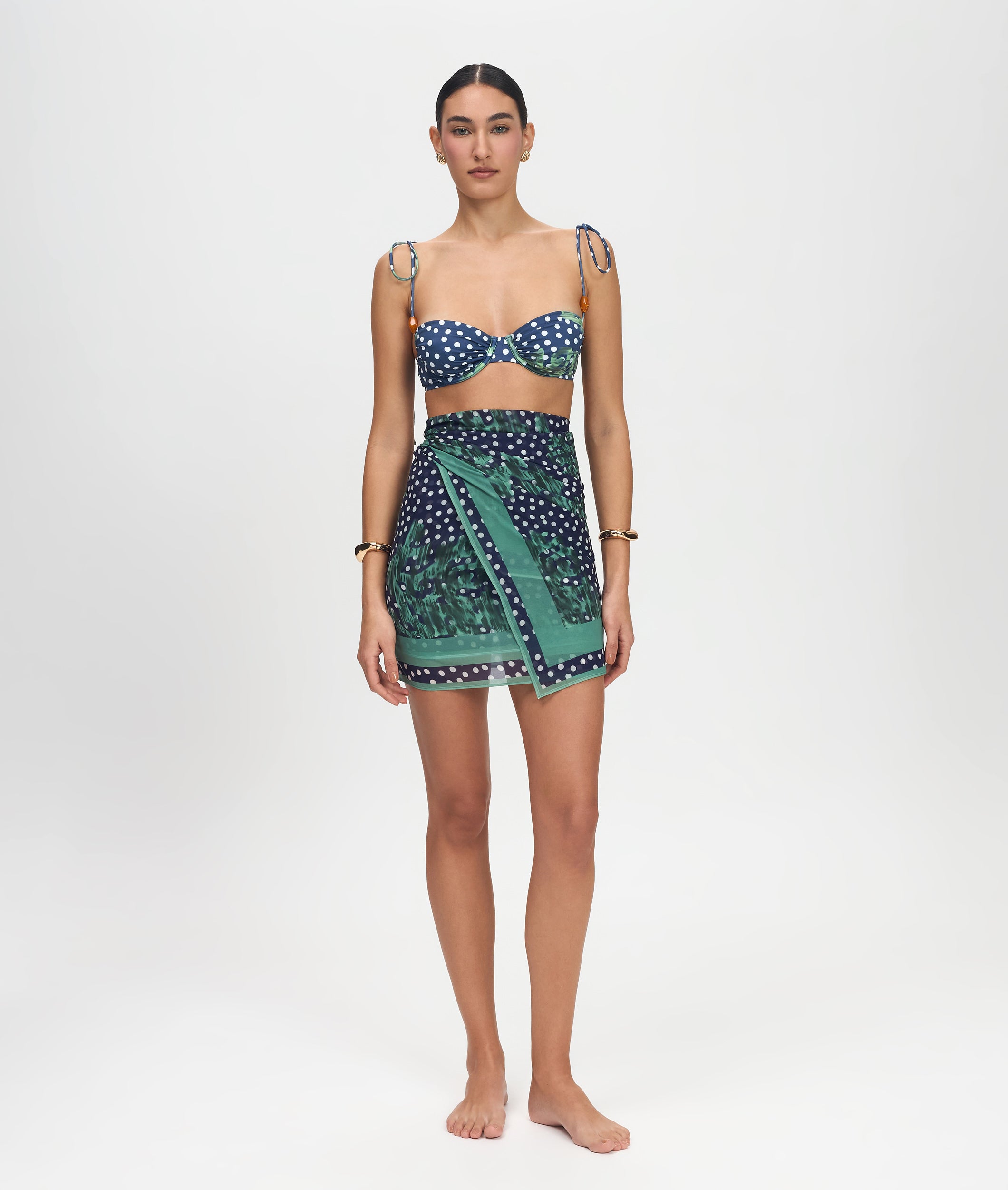 Woman wearing a patterned top and skirt on a white background