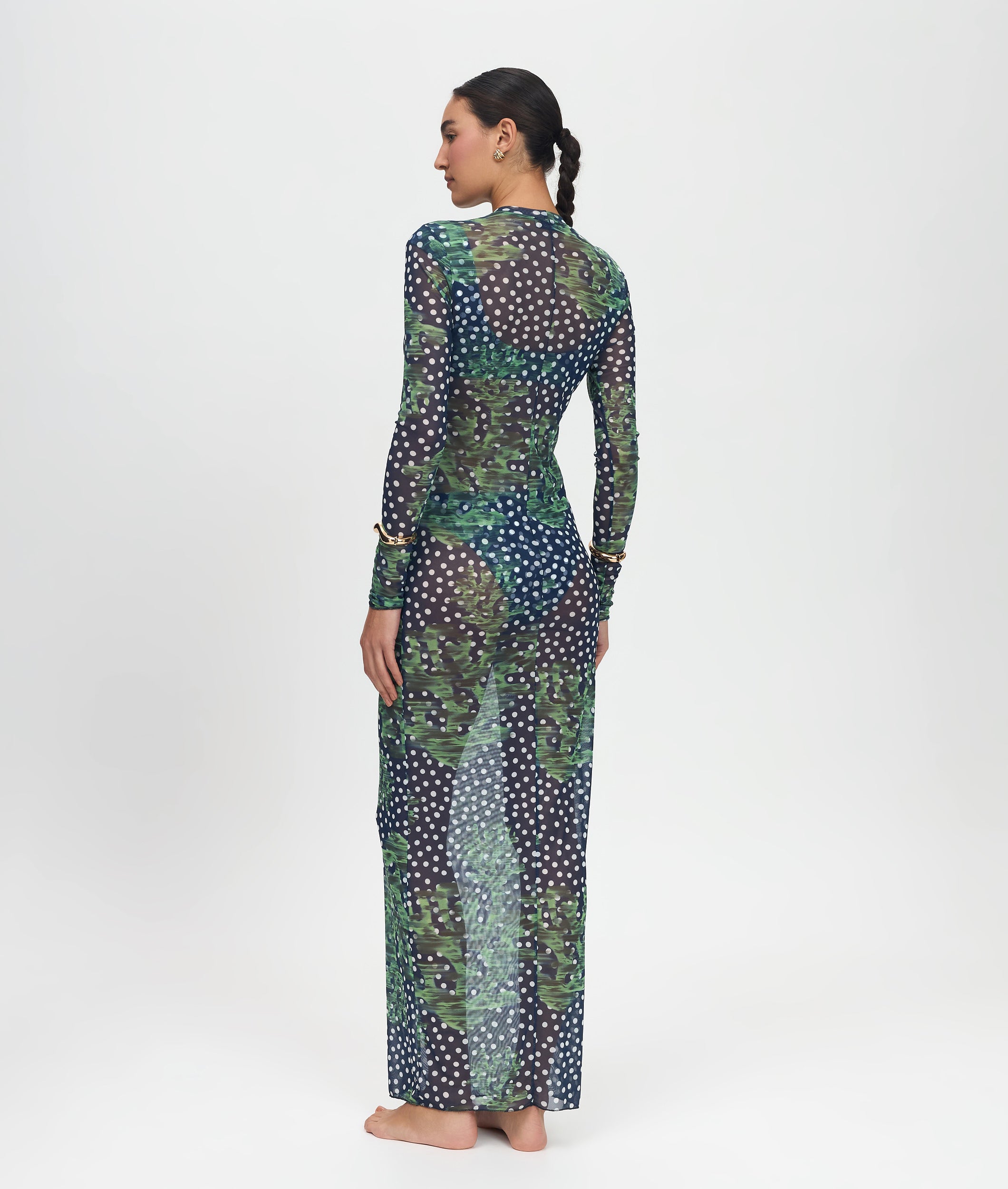 Woman wearing a long, patterned dress on a white background