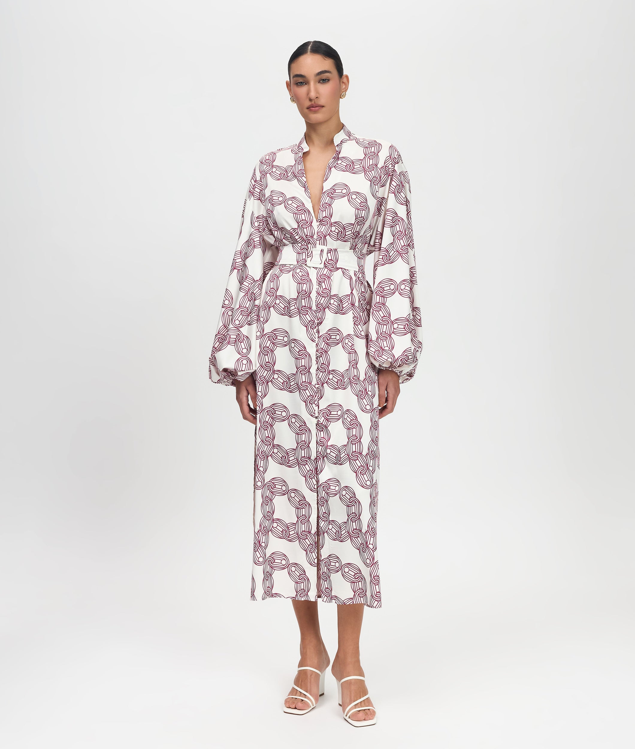 Woman wearing a pink and white patterned dress on a white background