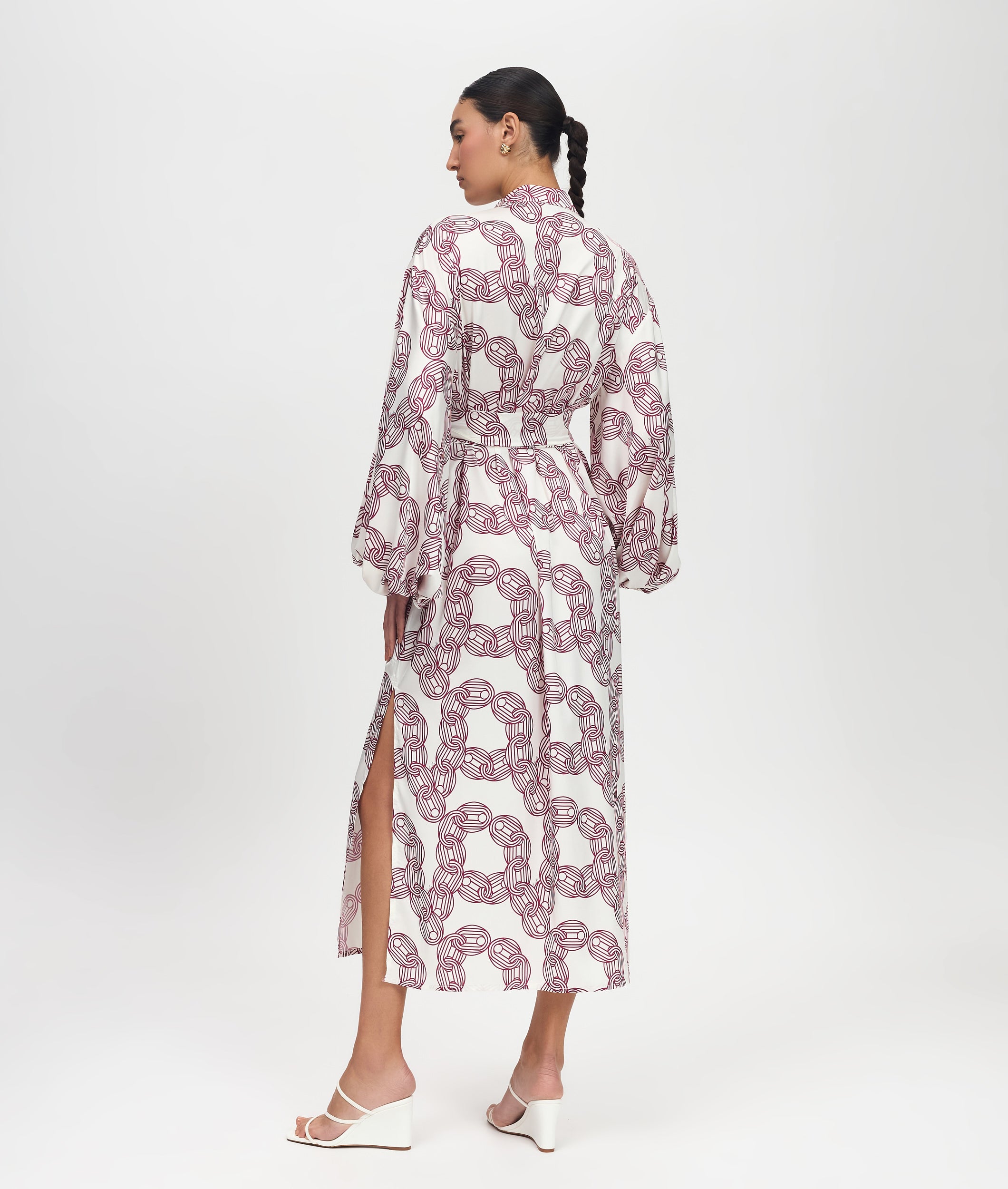 Woman wearing a patterned dress on a white background