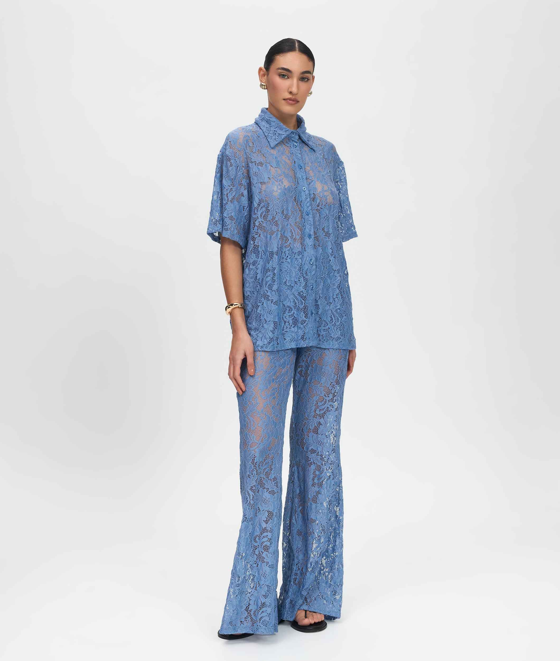 Woman wearing a blue lace outfit on a white background