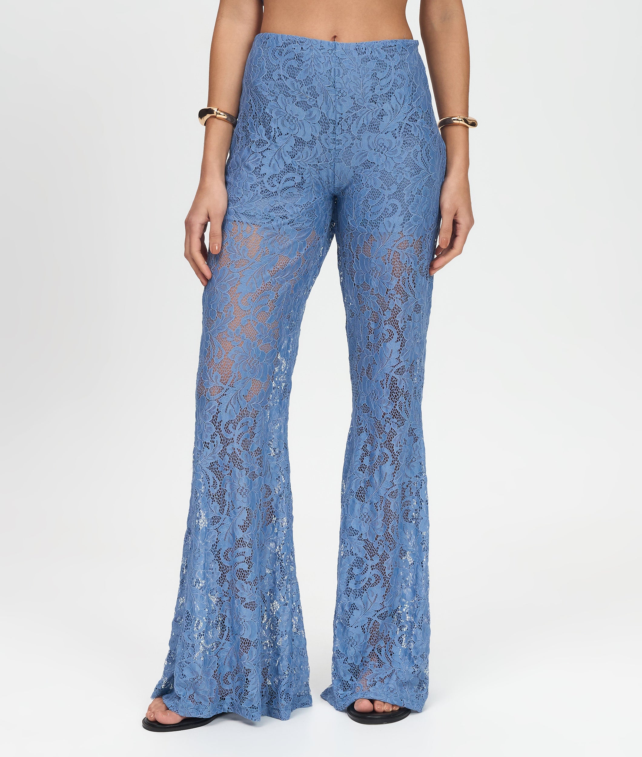Blue lace pants worn by a person on a white background