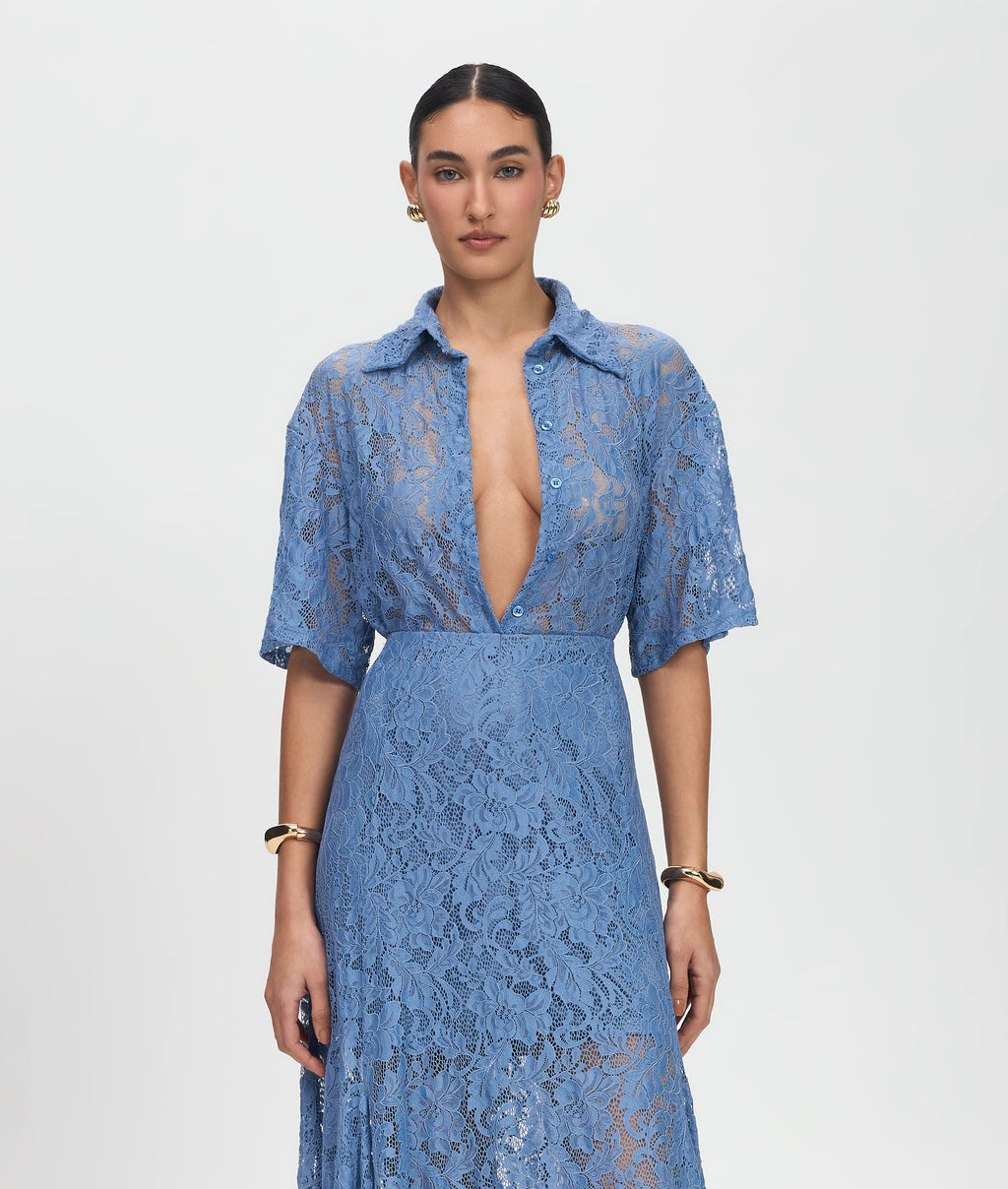 Woman wearing a blue lace dress on a white background