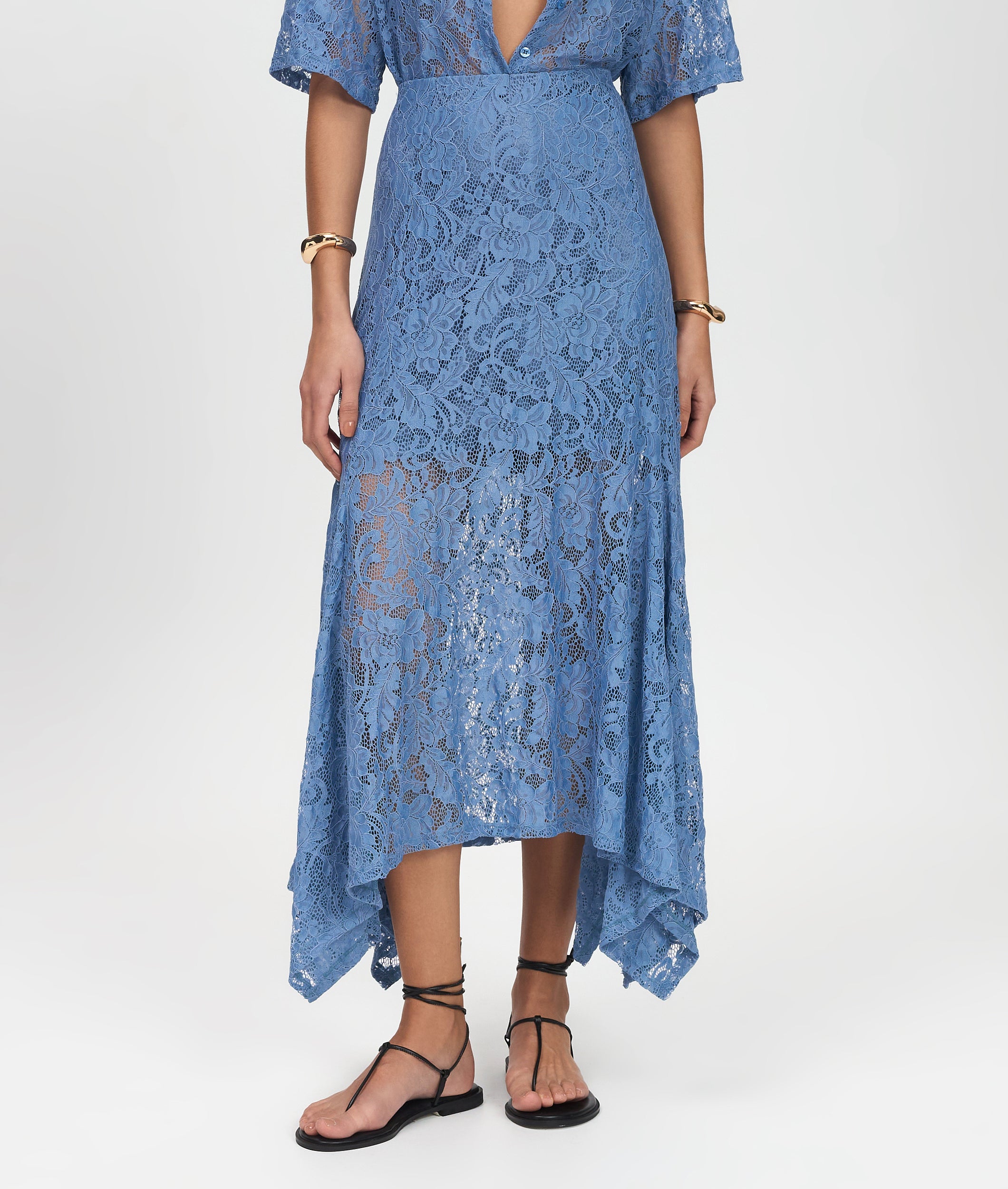 Blue lace dress worn by a person on a white background