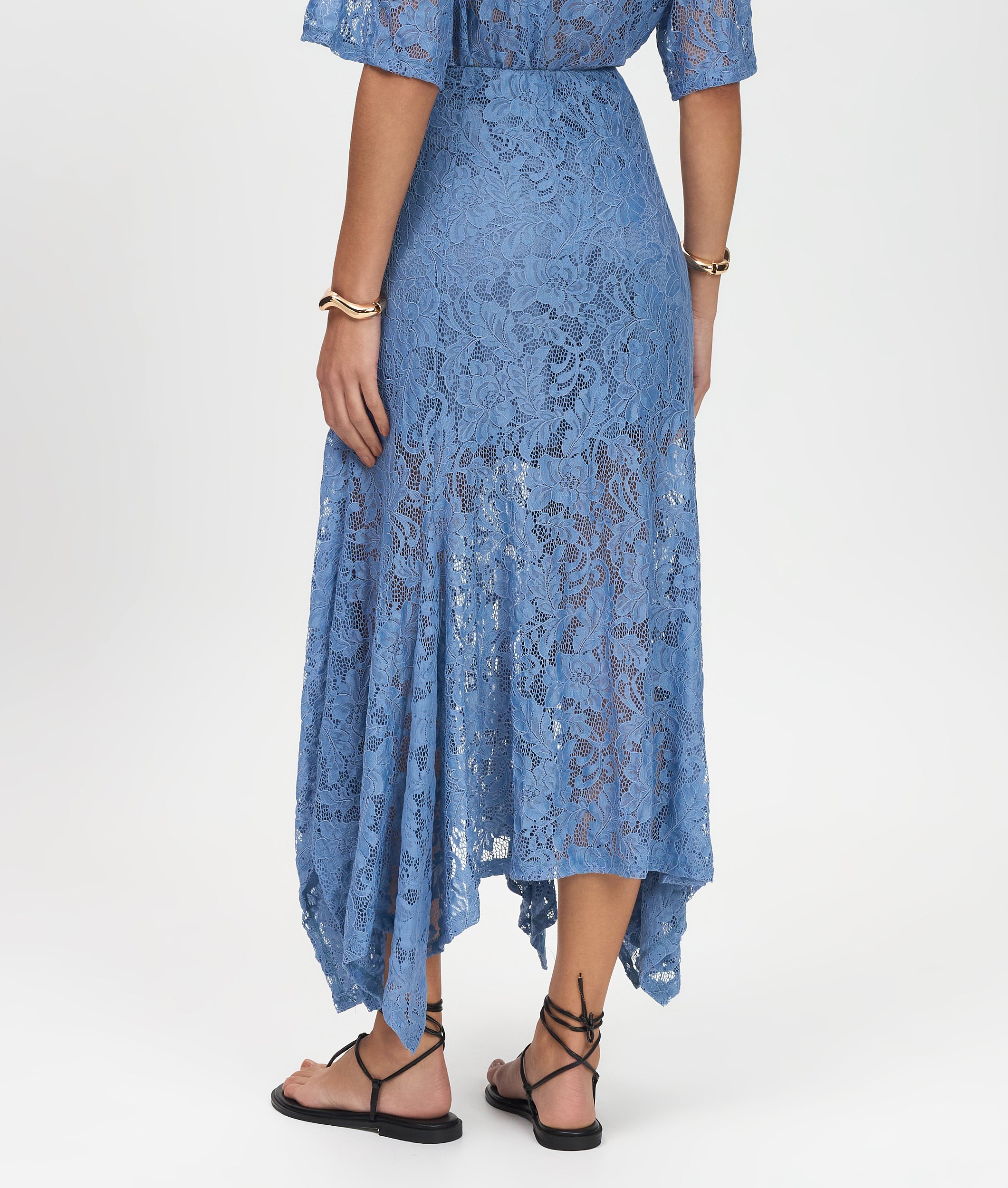 Blue lace dress worn by a person on a white background