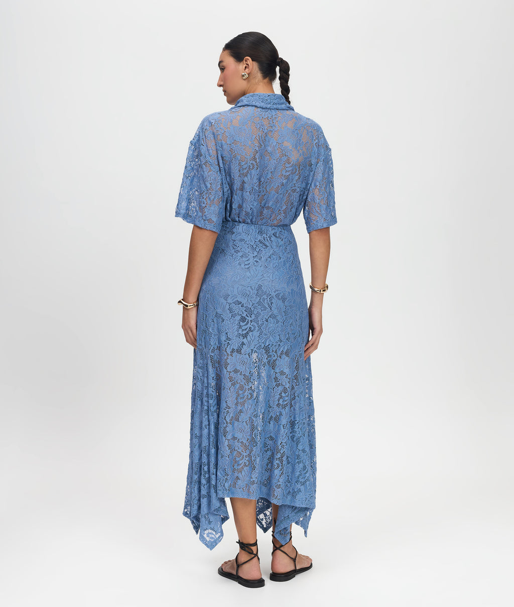 Woman wearing a blue lace dress on a white background