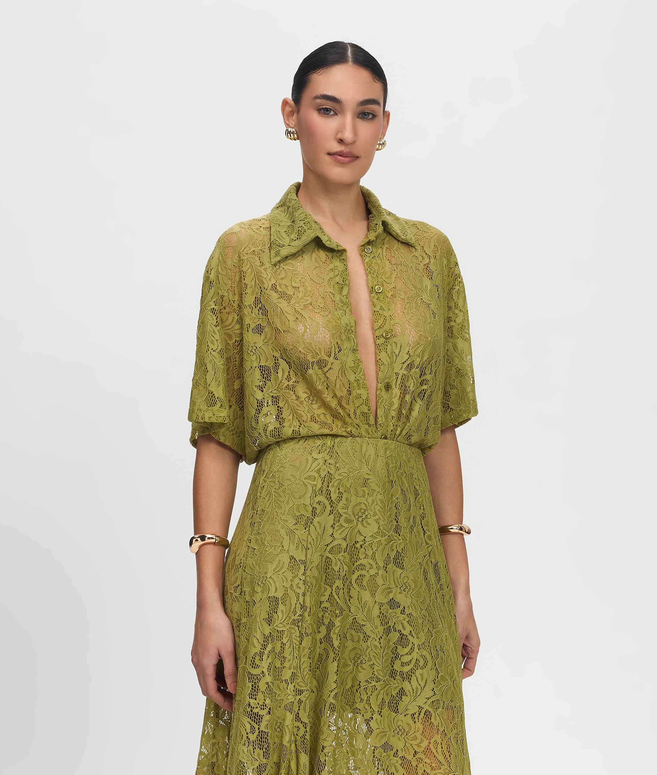 Woman wearing a green lace dress against a white background
