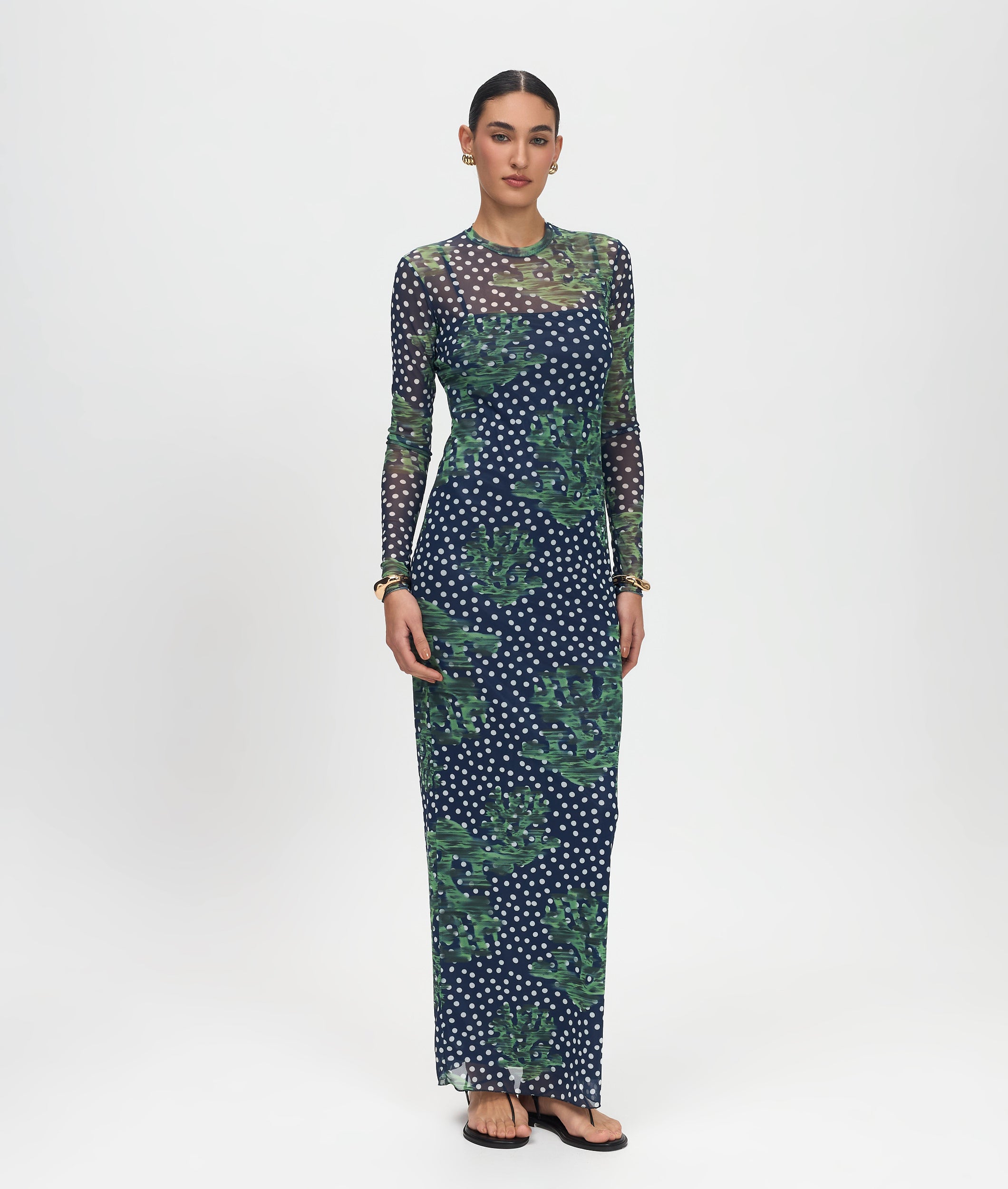 Woman wearing a long, patterned dress on a white background