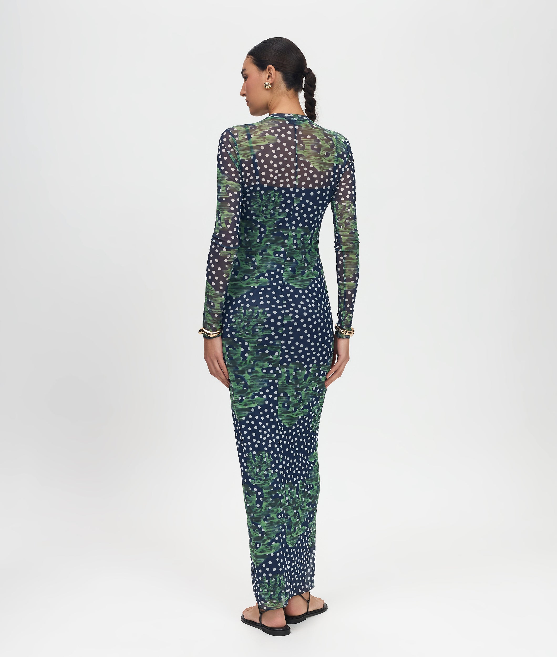 Woman wearing a long-sleeve dress with a floral pattern on a white background