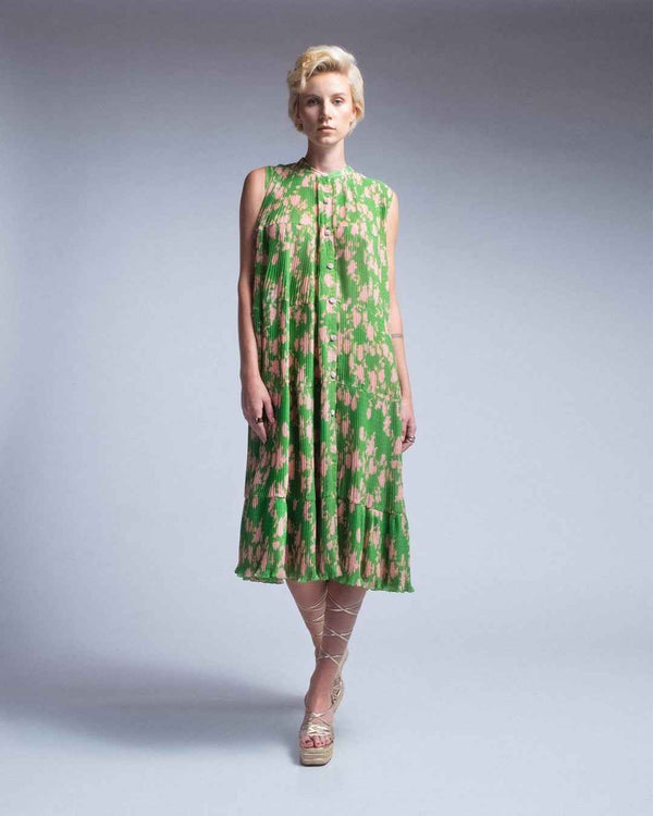 Woman wearing a green floral dress on a plain background