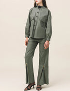 A person viewed from the back wearing green cargo pants with a button and zipper closure, and a matching green shirt.