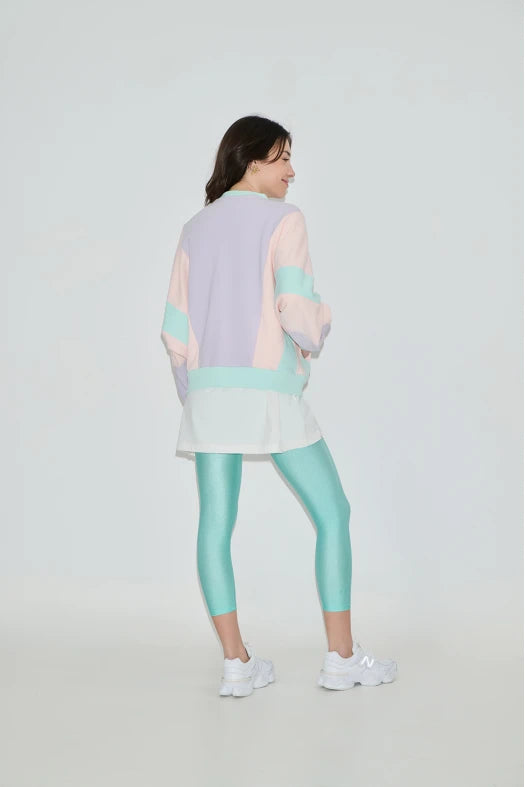 Person wearing a pastel-colored outfit with a light gray background