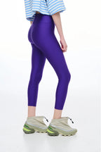Person wearing purple leggings with a white background