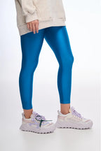 Person wearing blue leggings with a white background
