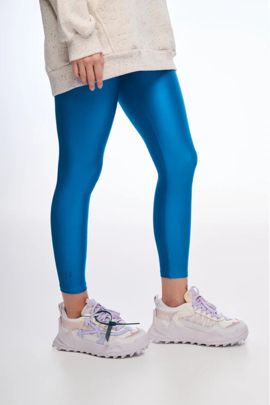 Person wearing blue leggings with a white background