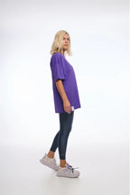 Person wearing a purple t-shirt and black leggings on a white background