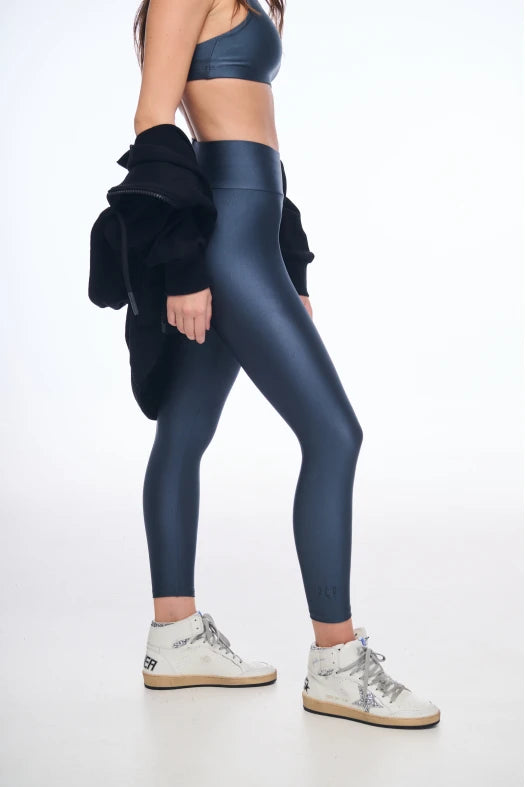 Person wearing blue leggings and a matching top on a white background
