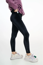 Person wearing black leggings with a white background
