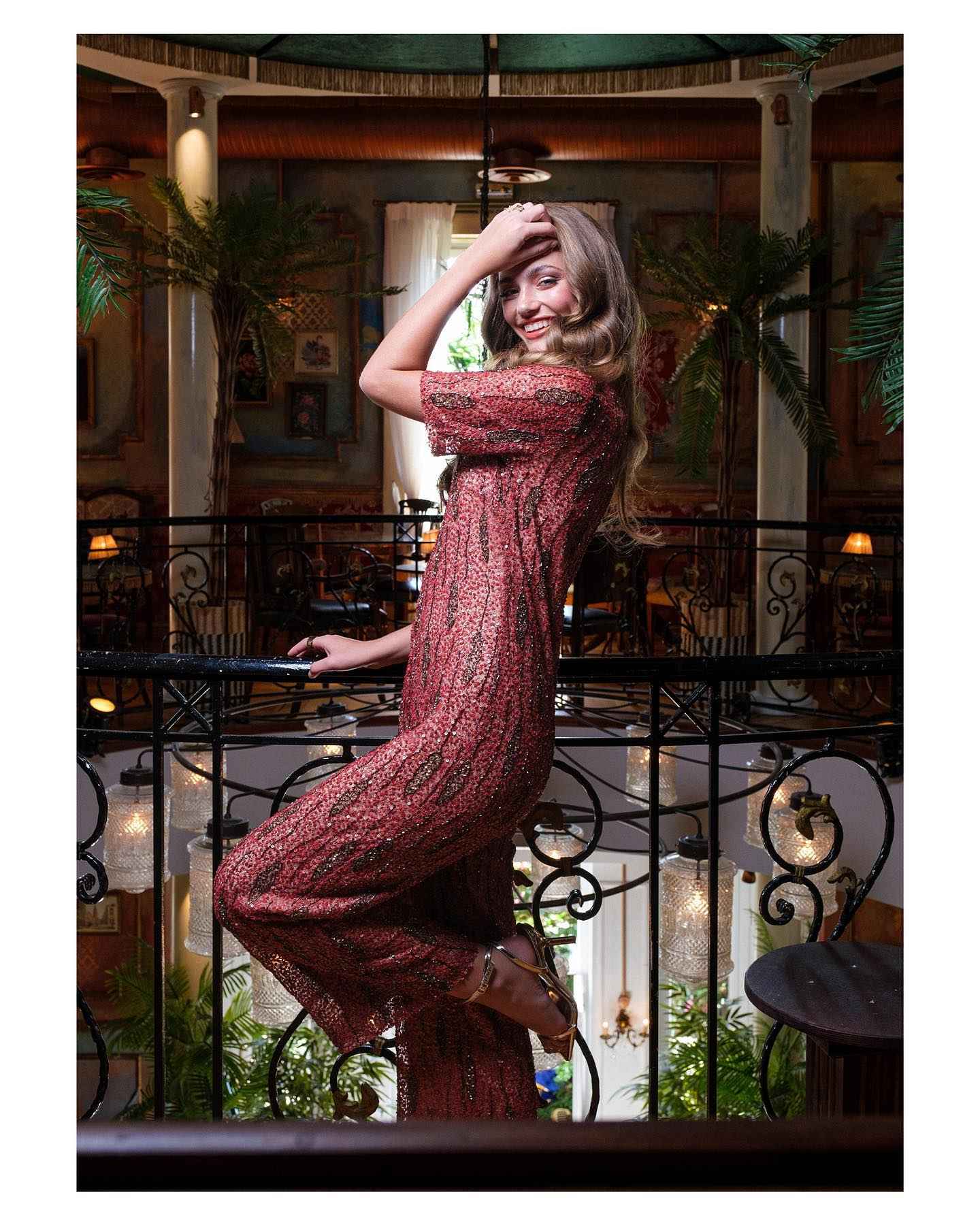 Woman in a red dress posing in an elegant indoor setting