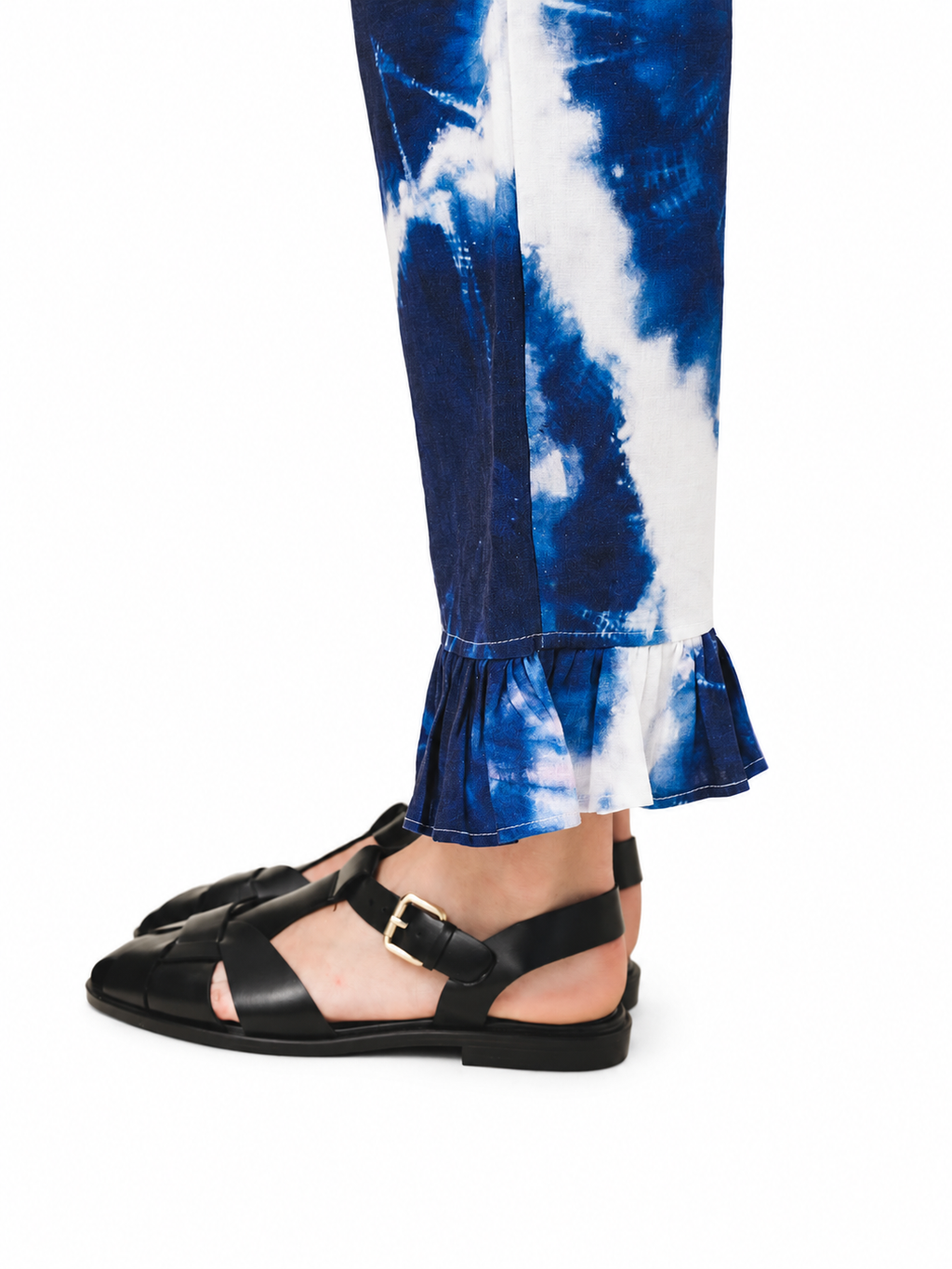 Love and Alicia CATALINA Tie-Dye Pants blue and white tie-dye flared trousers close-up detail showing ruffle hem with black fisherman sandals