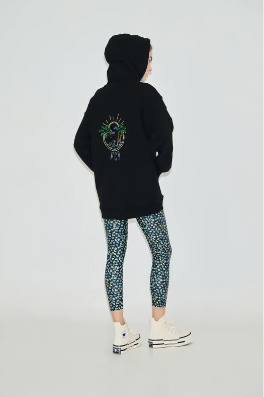 Person wearing a black hoodie with a colorful design on the back, standing against a white background.