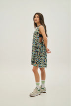 Woman wearing a patterned dress and sneakers on a white background
