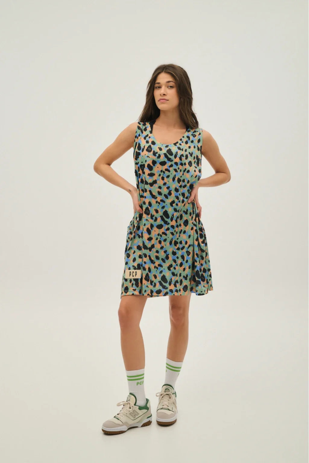 Woman wearing a patterned dress on a plain background