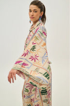 Woman wearing a colorful patterned outfit on a white background