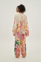 Person wearing a colorful floral onesie on a white background