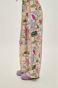 Colorful patterned pants with floral and geometric design on a plain background