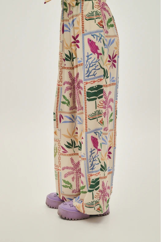 Colorful patterned pants with floral and geometric design on a plain background