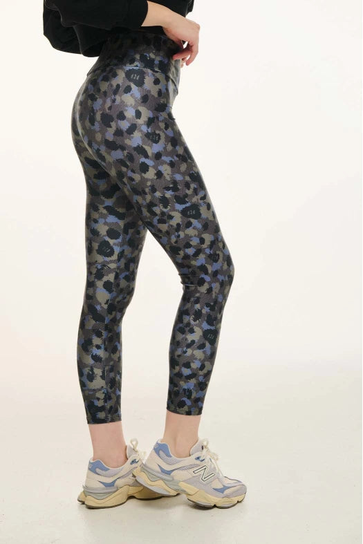Person wearing camouflage leggings on a white background