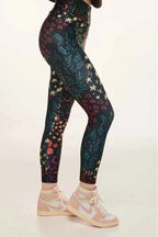 Leggings with star and moon pattern worn by a person on a beige background