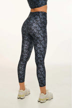 Person wearing navy leggings with white pattern on a white background