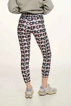 Person wearing colorful patterned leggings with a plain background