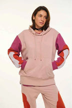 Person wearing a pink and red tracksuit on a white background