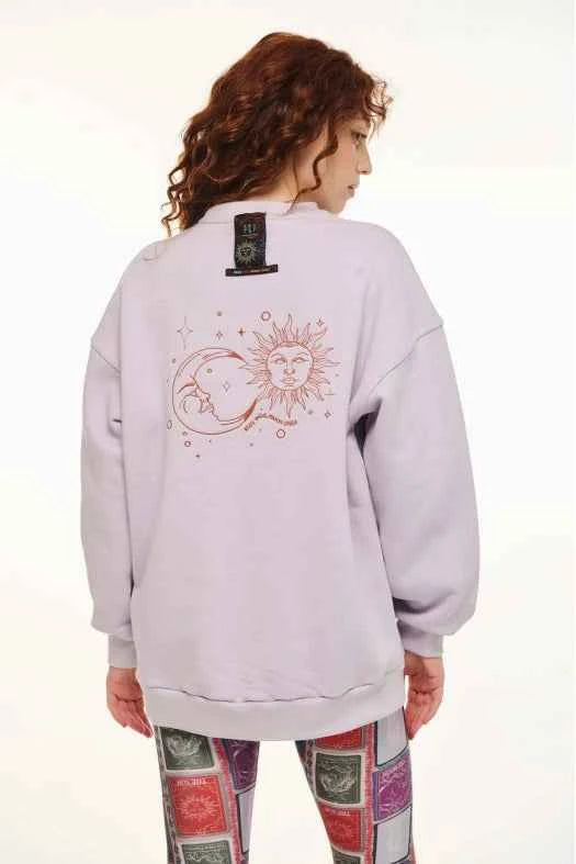 Person wearing a light gray sweatshirt with a sun and moon design on the back, standing against a white background.