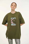 Person wearing an olive green t-shirt with a graphic design on a white background