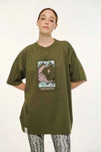 Person wearing an olive green t-shirt with a graphic design on a white background