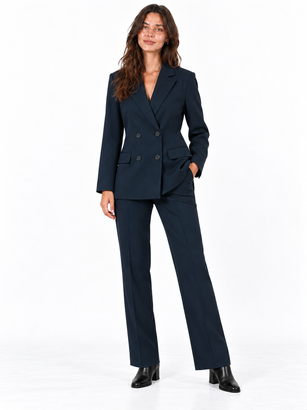 A woman modeling a dark navy blue double-breasted blazer and matching wide-leg trousers, paired with black ankle boots, against a plain white studio background.
