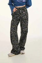 Person wearing camouflage pants and a blue jacket on a white background