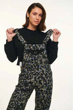 Person wearing camouflage overalls with a black shirt on a white background