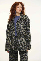 Person wearing a leopard print coat and pants on a white background
