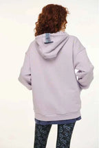 Person wearing a light gray hoodie with a white background