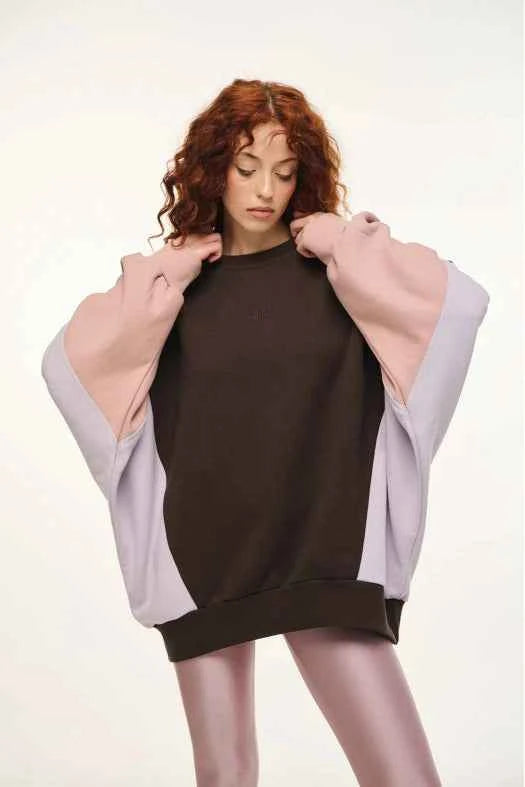 Woman wearing a black dress with a light purple jacket on a white background