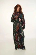 Person wearing a colorful floral outfit on a white background