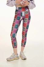 Person wearing colorful patterned leggings on a white background
