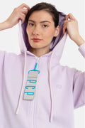 Woman wearing a light purple hoodie with a brand logo on a white background